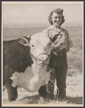[A woman posing with a cow]