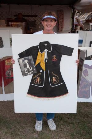 Primary view of object titled '[Curator of Nostalgia: A Woman Showcasing Vintage Kids' Costumes]'.