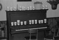 Photograph: [Cups on a piano at the home of Willard Watson, "The Texas Kid", 3]