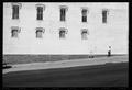 Photograph: [Man Walking up a Hill in a Town Square]