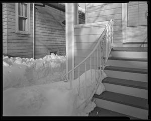[Snow piled next to a front porch]