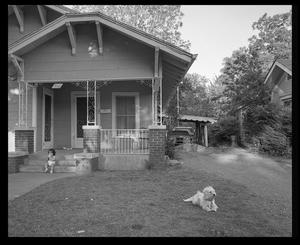 [Small girl and dog in front yard]