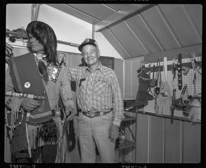 [Smiling man posing with a Native American mannequin]