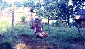 Child on village swing
