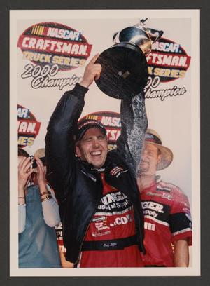 [Greg Biffle posing with the NASCAR Craftsman Truck Series trophy]