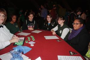 [Five UNT Students and Card Dealer at Red Poker Table]