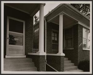 [Columns on the front porches of two homes]