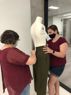 [Janelle McCabe and Piper Head installing historic dress artifacts]