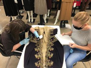 [Two students examining an eighteenth-century coat]