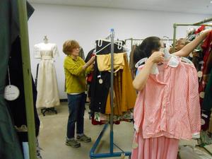 [Staff and volunteers hanging up garments]