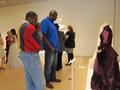 Thumbnail image of item number 1 in: '[Visitors observing a historic purple wedding dress]'.