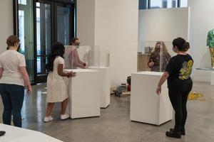[Staff placing pedestals at the entrance to the exhibition]