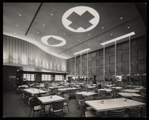 [A cafeteria with a cross and shield logo on the ceiling]