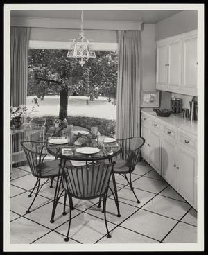 [A table and chairs next to a window in a kitchen]