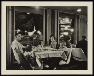 [A family seated in a restaurant at a Howard Johnson's]