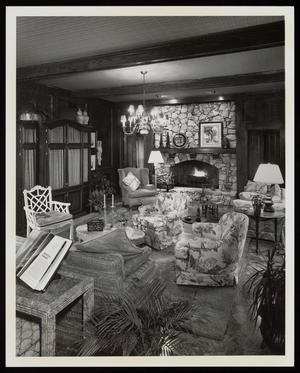 [A living room with a stone fireplace and floral-patterned chairs]