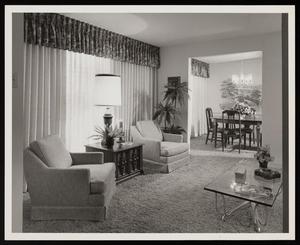[Interior of a living room with furniture near curtained windows]