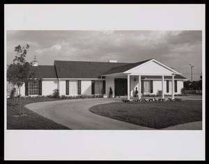 [Exterior of a house with a porte-cochere over a curving driveway]