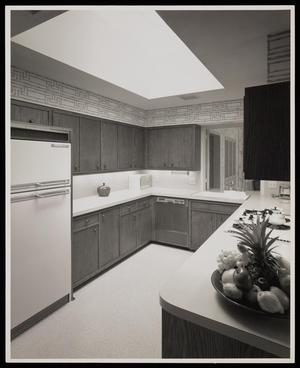 [A kitchen with wooden cabinets and a bowl of fruit]