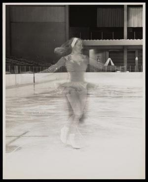 [A woman in a dress ice skating]