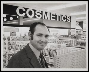 [A man in a store's cosmetics department]