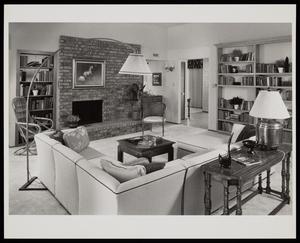[A living room with a fireplace and corner sofa]