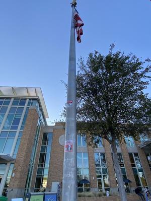 [A Communist Sticker on a Flagpole with an American Flag on the University of North Texas Campus]