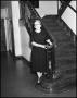 Photograph: [Woman stands at the bottom of the stairs]