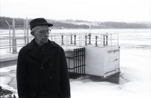 [An elderly man in front of a small structure, 1]