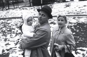 [A man, woman, and child outside in snow]