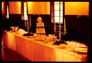 [Table decorated with a wedding cake and candelabra]