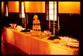 Photograph: [Table decorated with a wedding cake and candelabra]