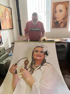 [Drag artist Richard D. Curtin standing with a large print-out]
