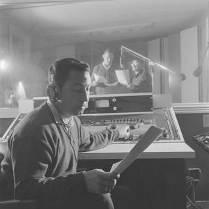 [A man looking at paper in a recording room, 7]