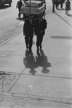 [Two men walking alongside a busy road, 5]