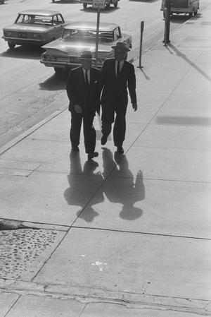 [Two men walking alongside a busy road, 3]