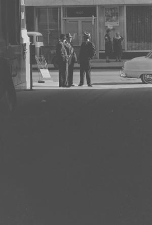 [Distant view of men talking on a street, 2]
