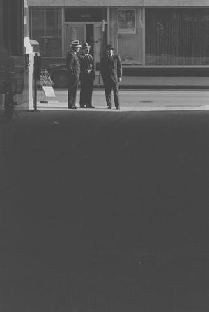 [Distant view of men talking on a street, 4]