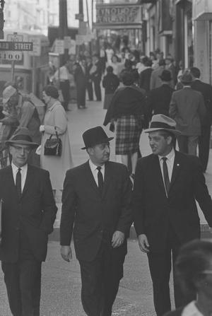 [Three men walking down a crowded street, 3]