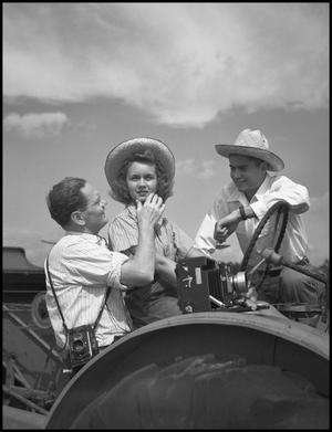 [Two men and a woman on a tractor]