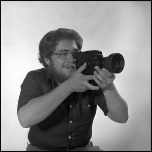 [Lewis Abernathy posing with film camera, 2]