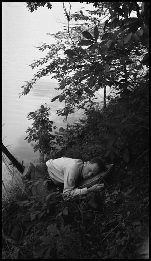 [Man sleeping on a river bank, 2]