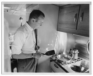 [A Man Frying Eggs in the Kitchenette]
