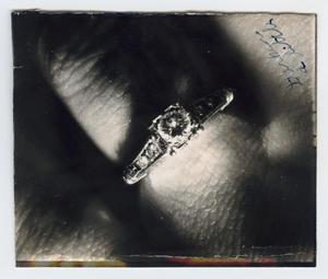 [Folded photograph of a ring on a finger]