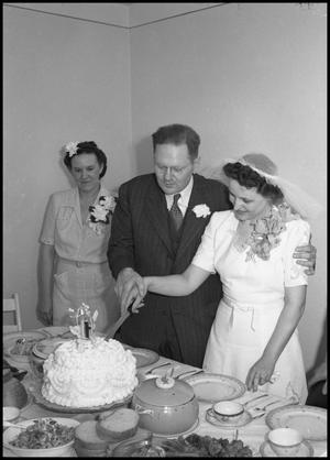 [Joe and Bernice Clark cutting their wedding cake]
