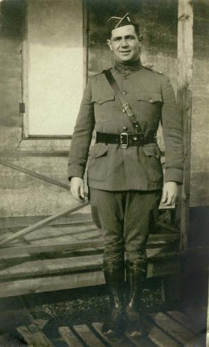 [Photograph of a soldier in uniform at military camp]