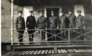 [Seven men in uniform having their portrait taken]