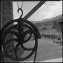 Photograph: [Pulley wheel hanging outside, 5]