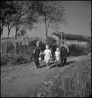 [Boys and girls walking along a country road]