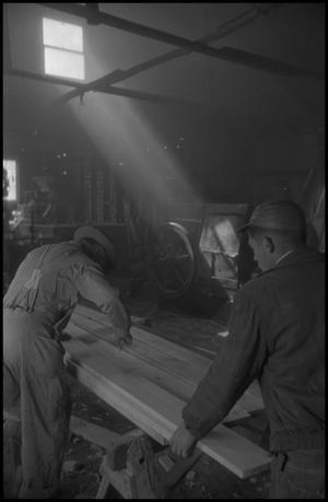 [Photograph of two men working with wood]